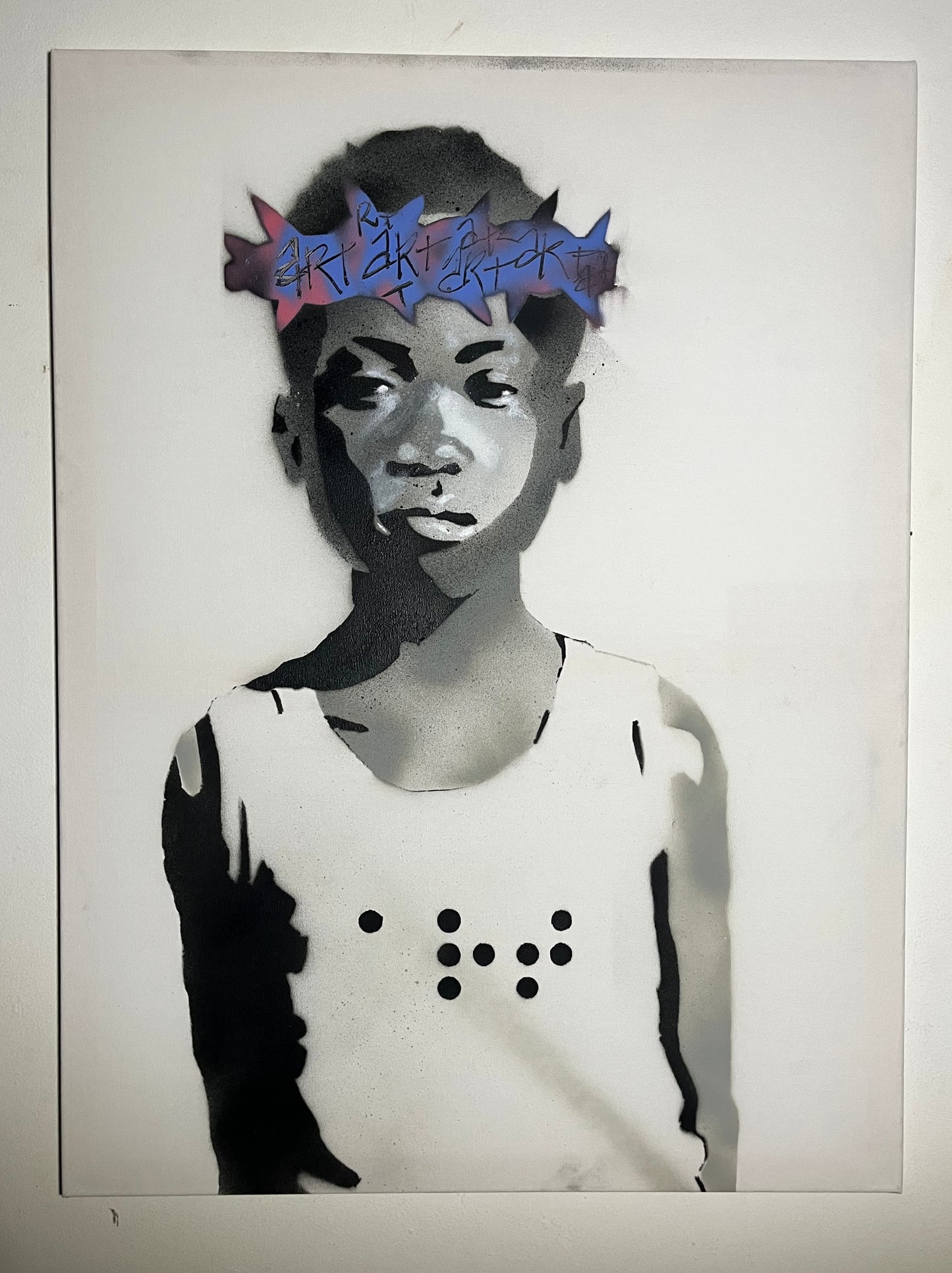 Peinture en noir et blanc d'un jeune garçon portant une couronne bleu et mauve avec 'art' gravé dessus et un t-shirt sur lequel est inscrit 'art' en écriture braille.