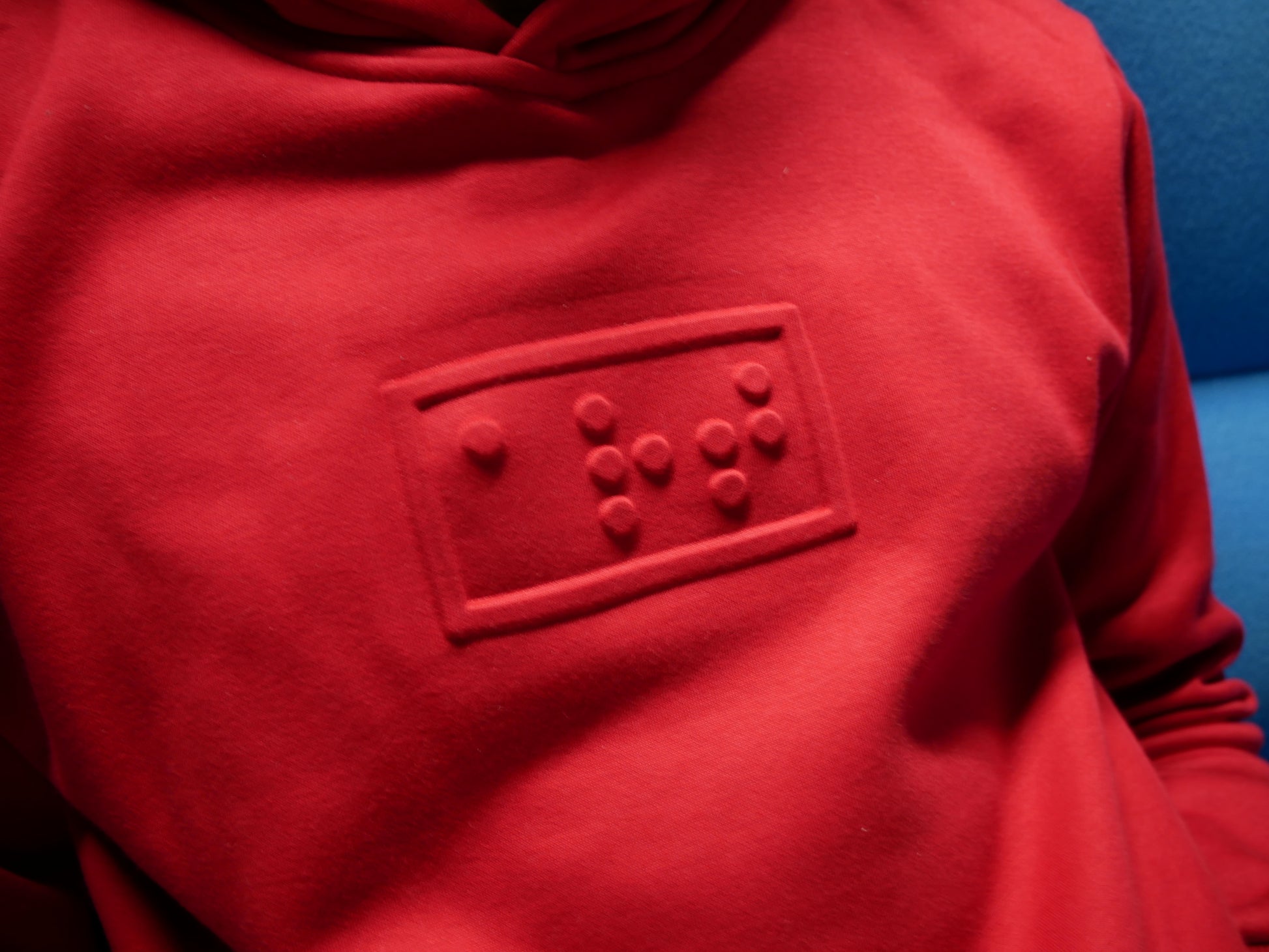 art embossé en braille sur un hoodie rouge