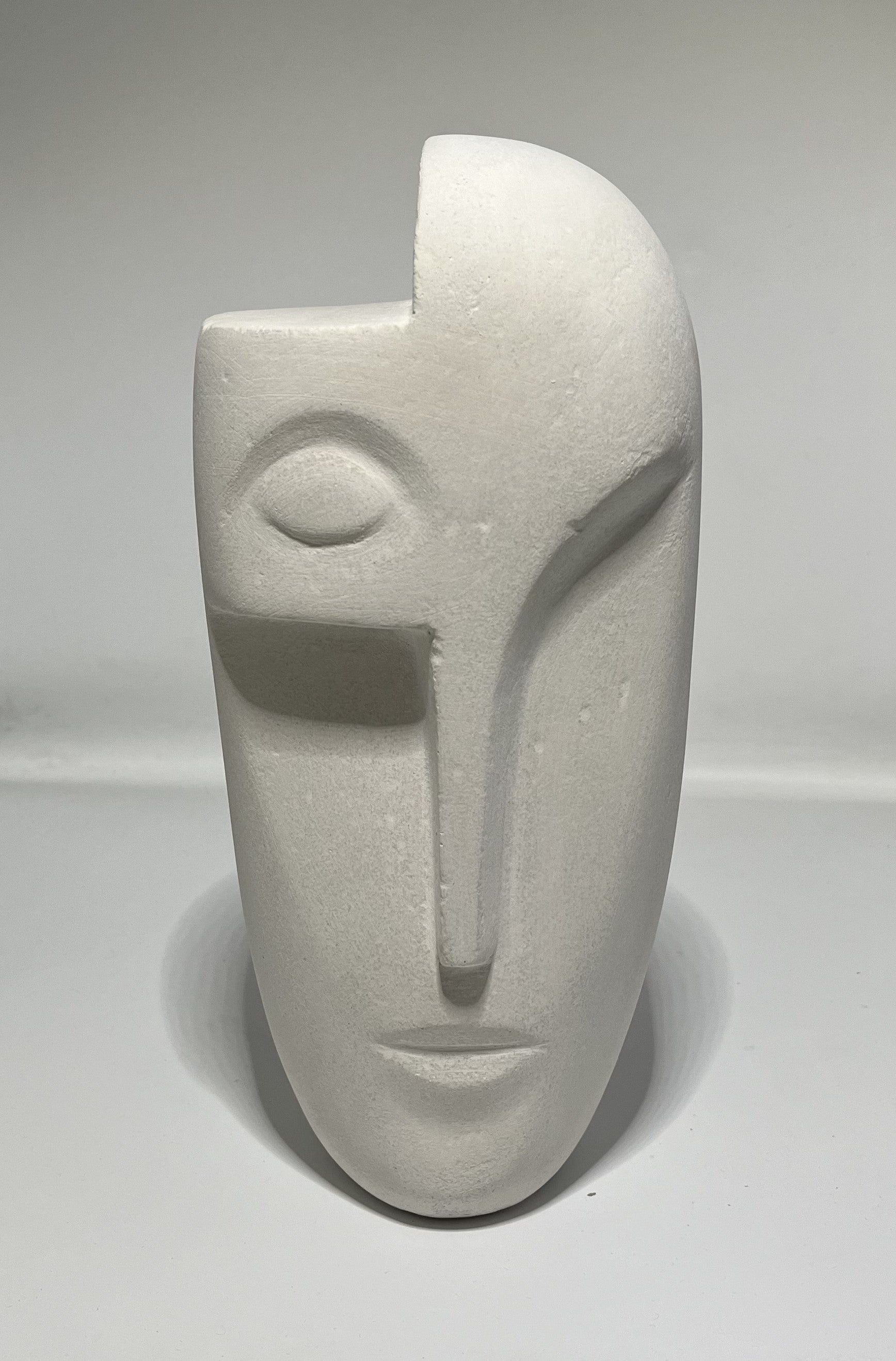 Le visage sculpté est une œuvre d'art, Un hommage à la beauté humaine, Les yeux fermés, le nez long, Une expression de paix et de sérénité.