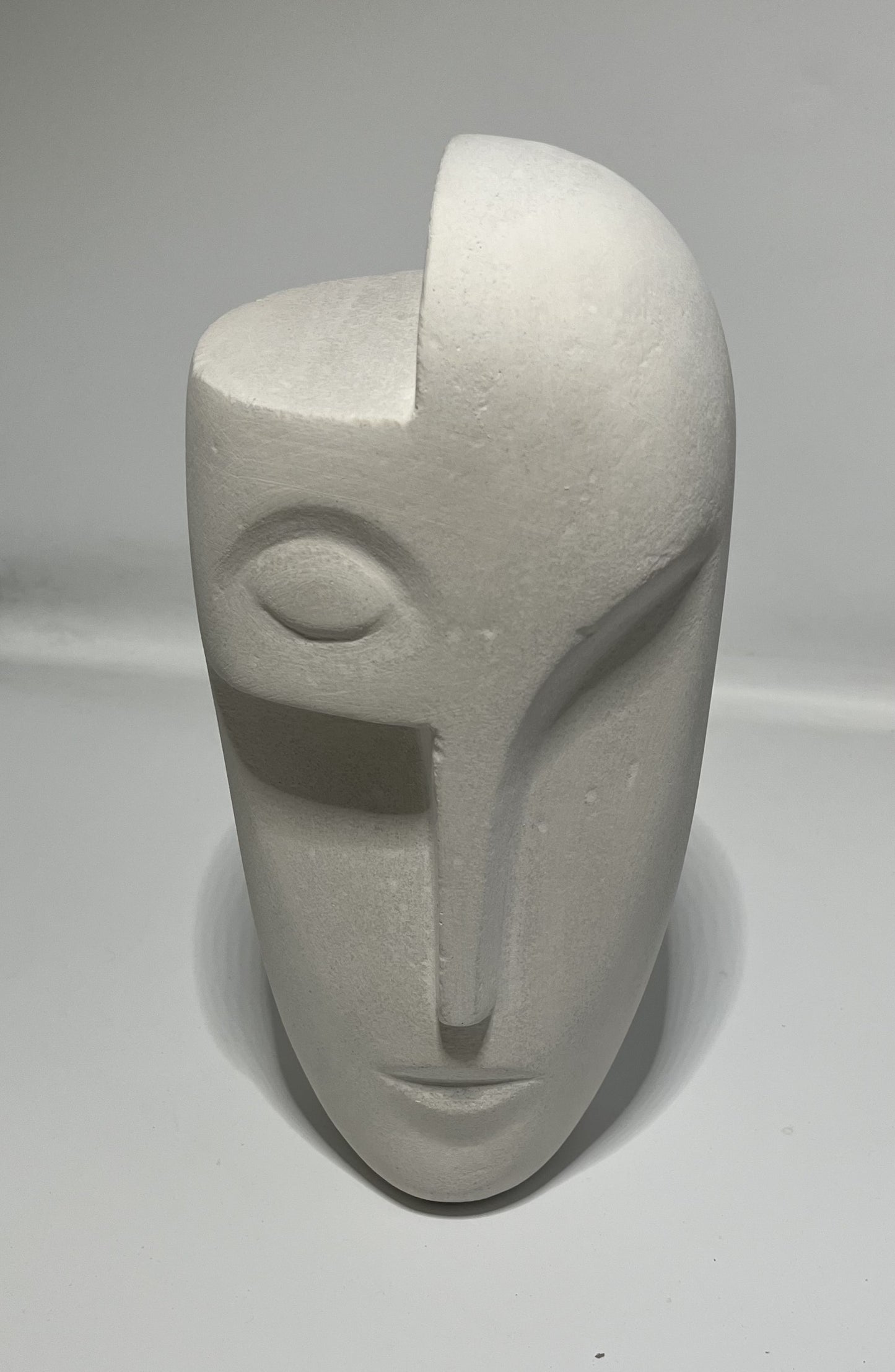 Le visage sculpté est une œuvre d'art, Un hommage à la beauté humaine, Les yeux fermés, le nez long, Une expression de paix et de sérénité.